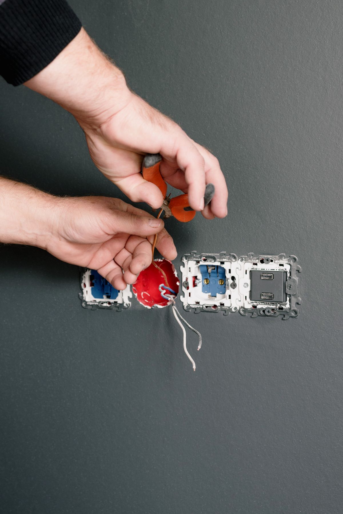 Electrician installing wall sockets and switches